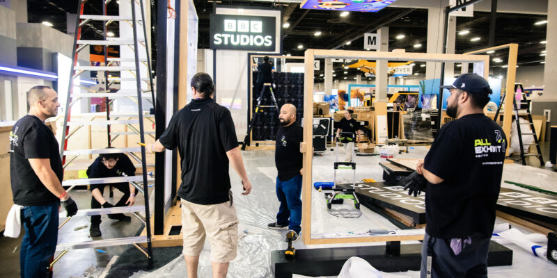 Trade show crew organizing booth components on the show floor.