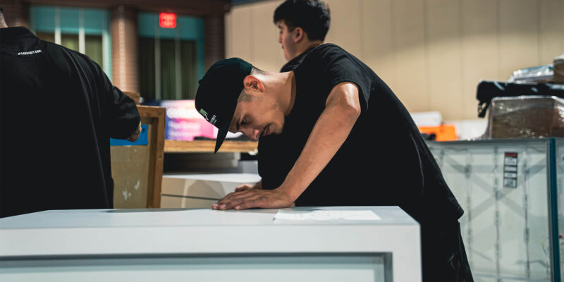 Worker assembling a trade show booth counter during installation.