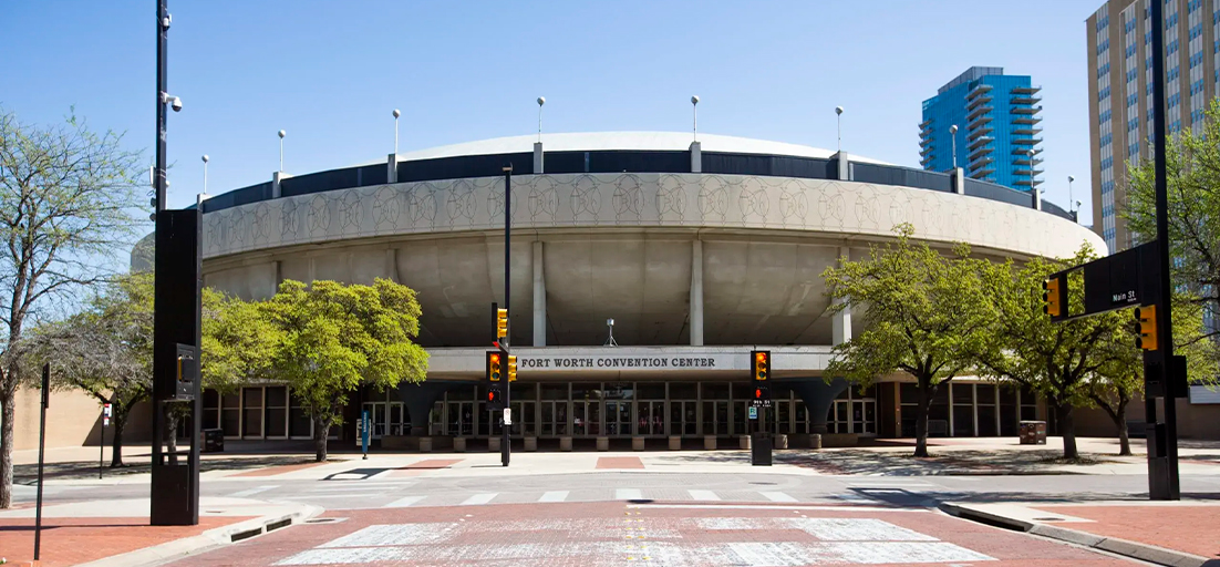 Exterior view of the Fort Worth Convention Center with circular architecture and trees in front.