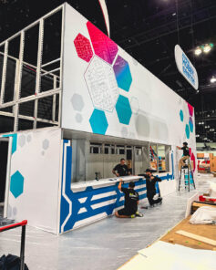 Completed trade show booth with colorful graphics and hexagon designs.
