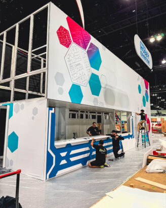 Completed trade show booth with colorful graphics and hexagon designs.