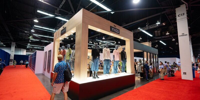 The YNSD apparel shop window bays and mannequin display in booth 4464 at D23 2026