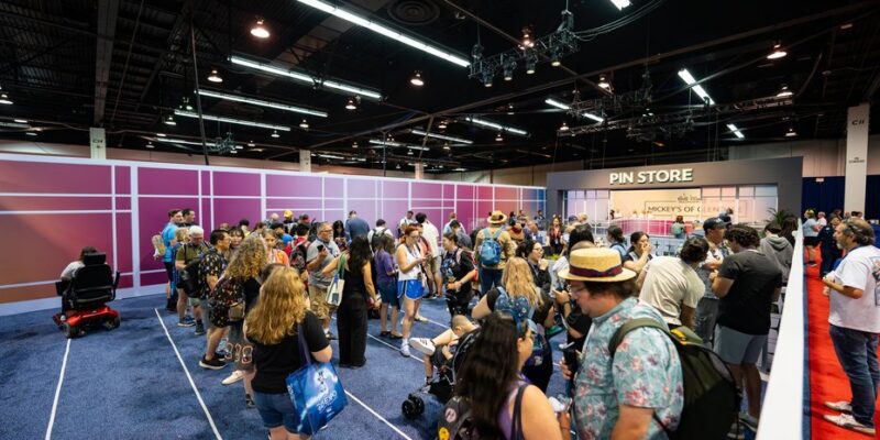 Guests queueing at the pin store frontage in the Walt Disney Imagineering retail block