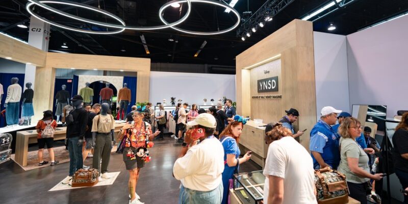 Casework, display cases and the ring-light ceiling on the YNSD shop floor at D23 2026