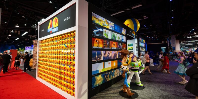 Anniversary wall and character statues inside the Pixar pavilion at D23 2026